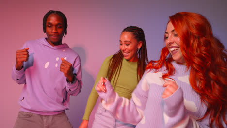 Studio-Shot-Of-Young-Gen-Z-Friends-Dancing-At-Club-Against-Pink-Background-4